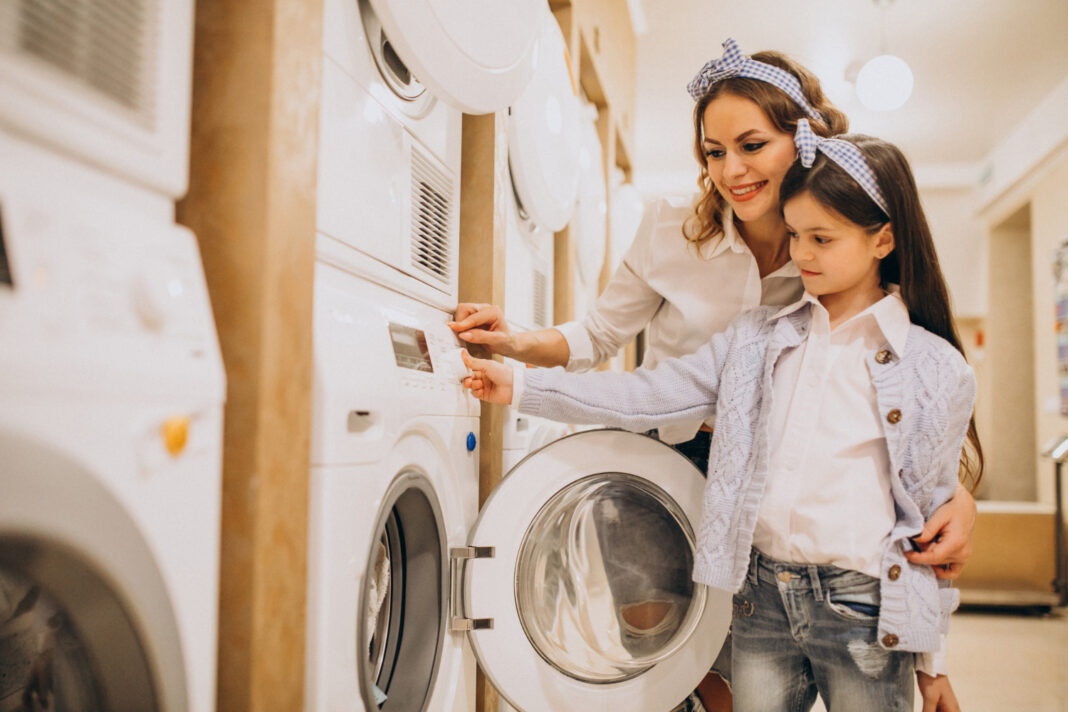 mother-with-daughter-doing-laundry-at-self-serviece-laundrette