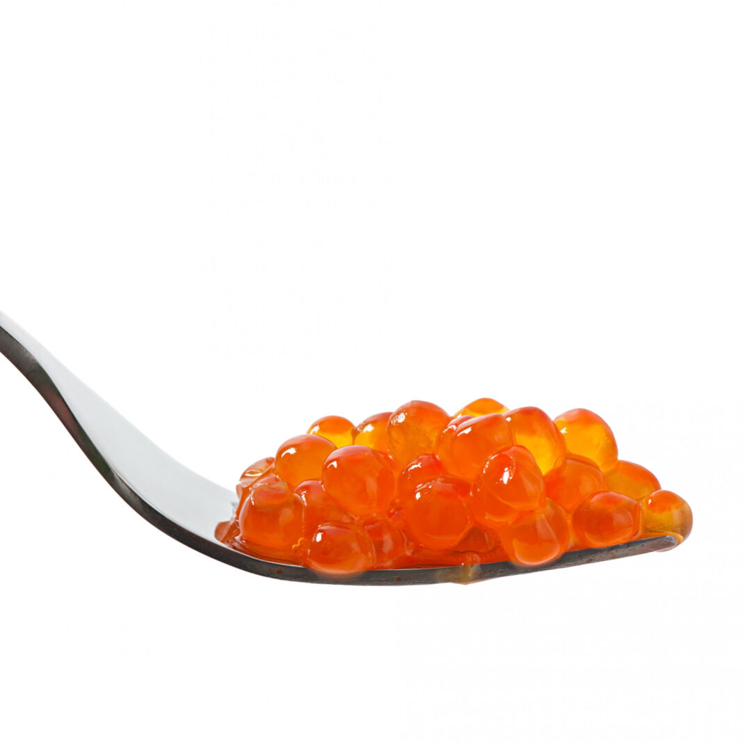 red-caviar-on-a-fork-isolated-on-white-table